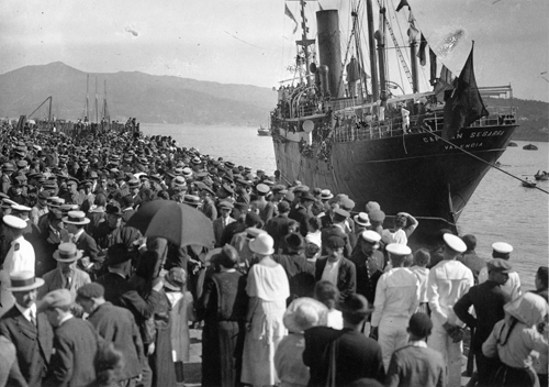 Foto en blanco y negro del año 1915 de un barco con multitud de inmigrantes esperando para embarcar para las Americas