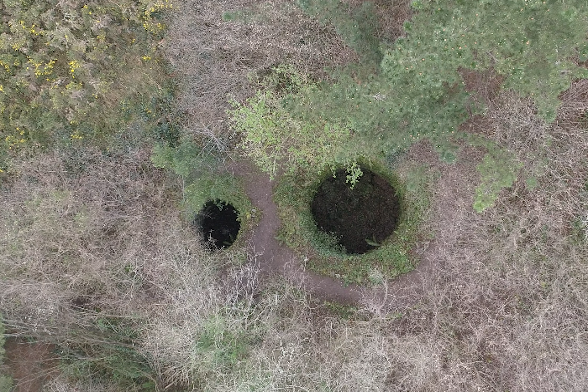 foto cenital en la que se aprecian los dos pozos excavados en la tierra correspondientes a dos pozos de nieve