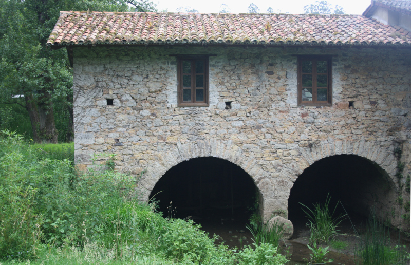 foto del molino de Requexu en el pueblo de Loriana. Es una construcción de piedra de 2 plantas. En la parte inferior tiene 2 arcos por los que pasaba el agua al interior del molino